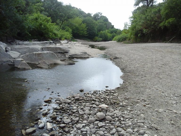 Un filet d'eau coule dans la rivière sous le pont de Tharaux